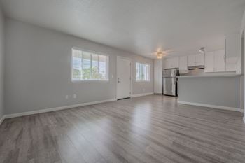 the living room and kitchen of an empty house with wood floors at Napa Green Apartments LLC, Napa